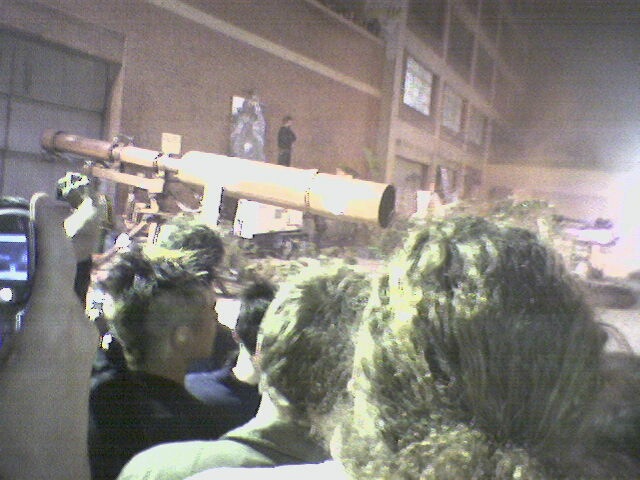 a crowd of people watching the action on a television screen
