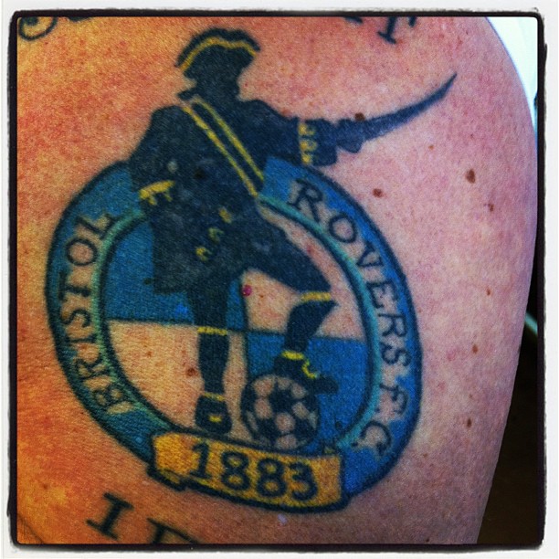 a tattoo on the leg shows a guy with a football helmet and sword