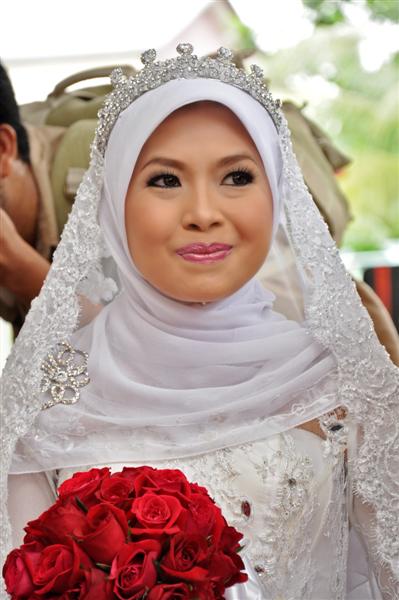 a woman dressed in white with red roses