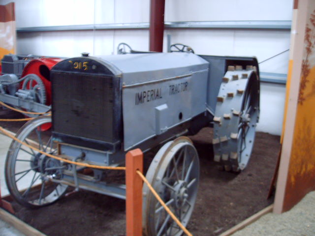 an old tractor sitting inside of a museum exhibit