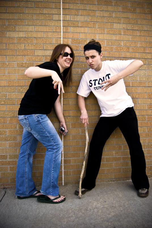 two people are standing next to a wall with a rope