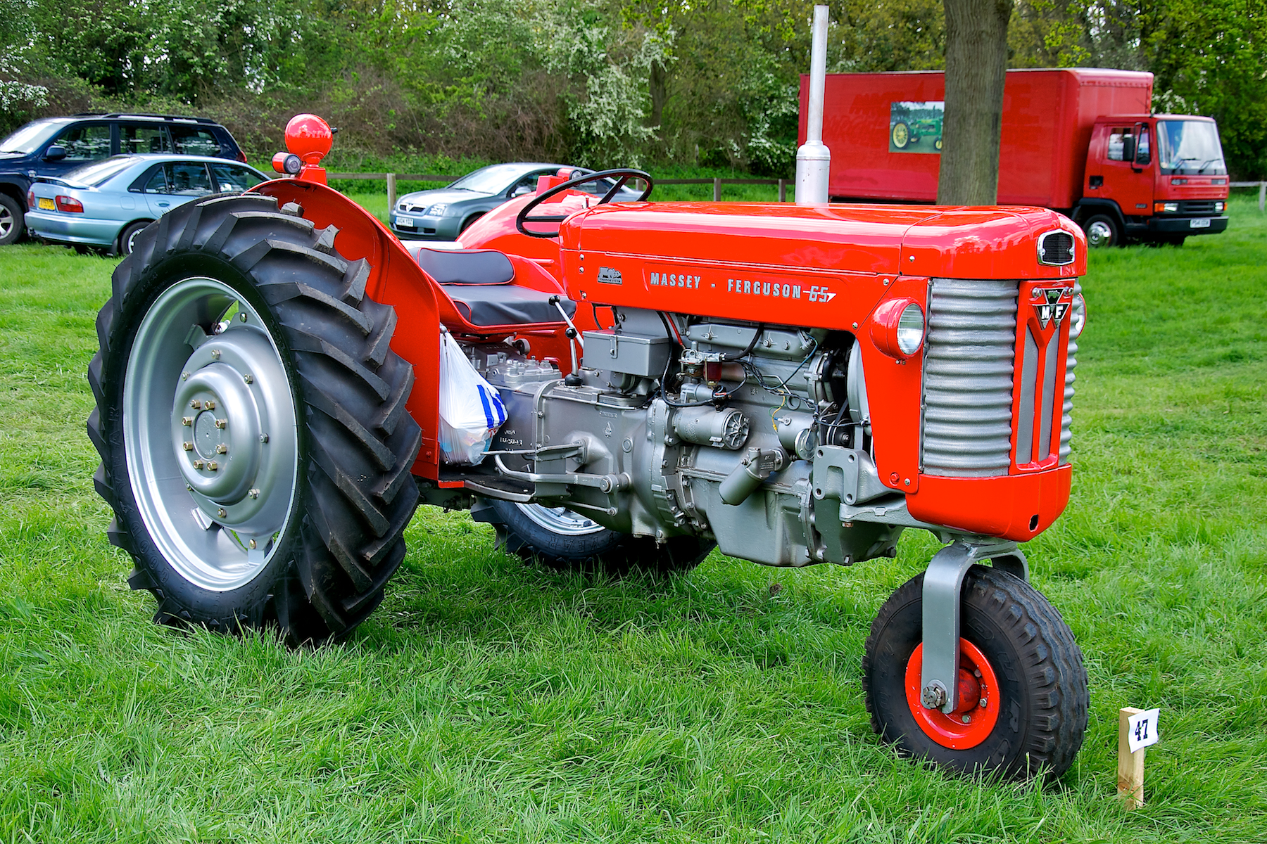 an old red tractor is on display in a park