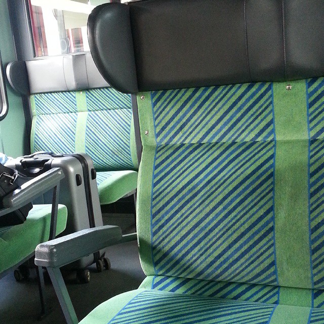 a po taken inside of a train seat showing the blue and green stripes on the side