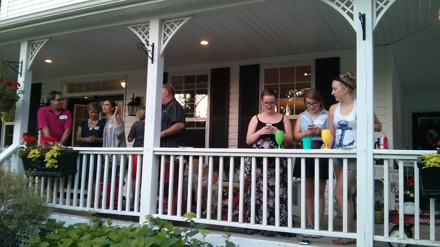 people outside of a house that are having tea