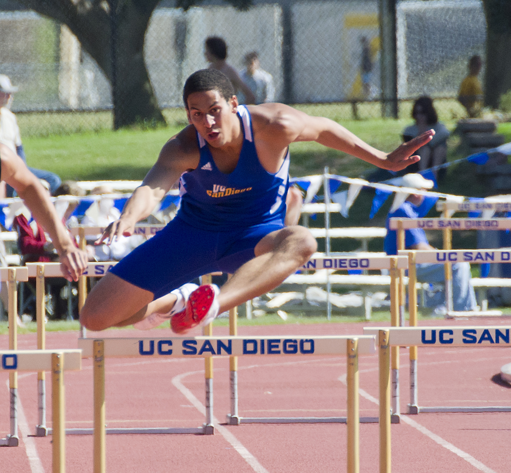 man jumping over hurdles in track and field event