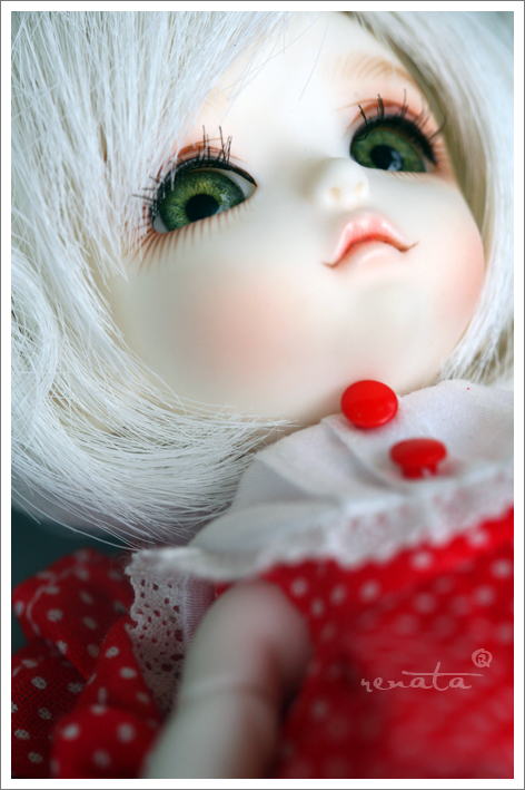 a close up of a doll with big green eyes
