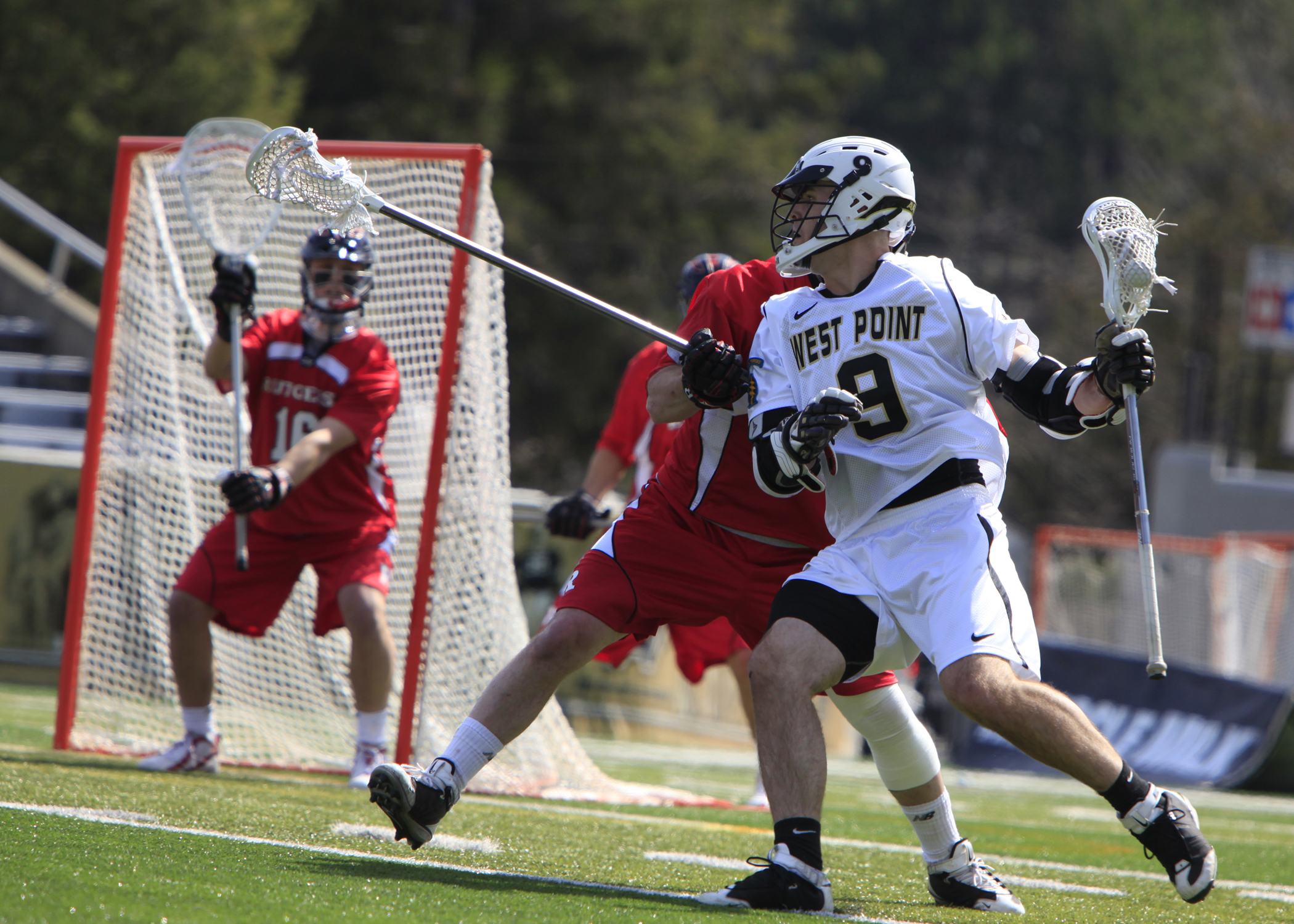 a couple of men playing a game of lacrosse