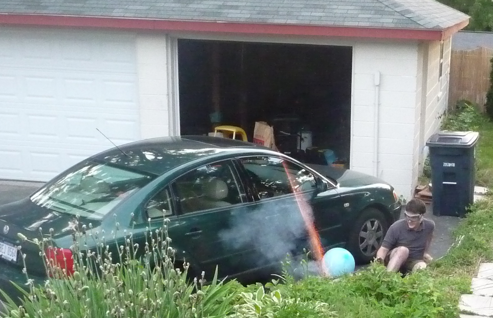 two men in the driveway with some cars