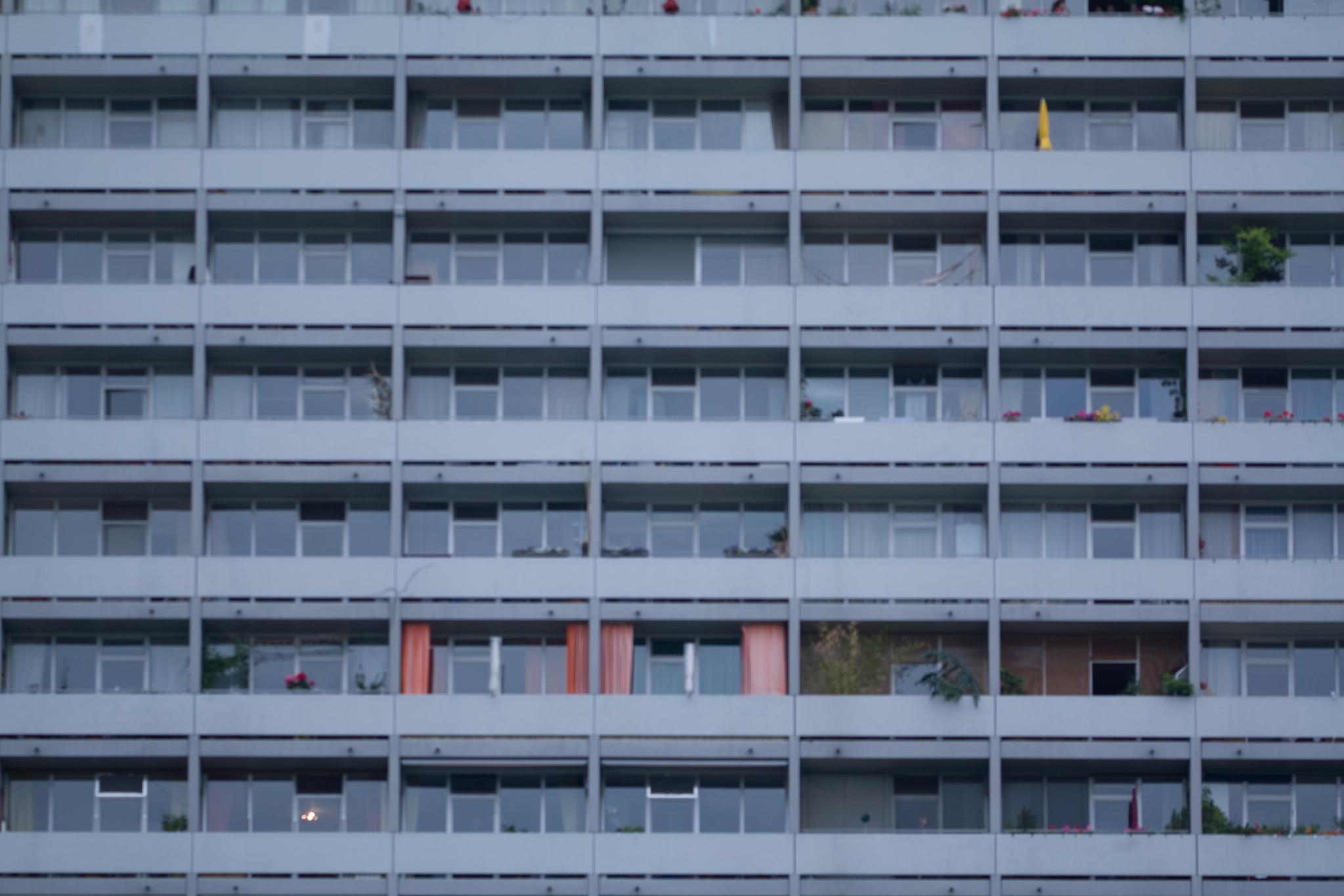 an apartment building that has many windows and balconies on the sides