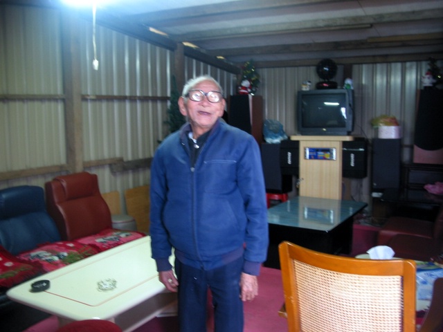 an old man is standing in front of the television