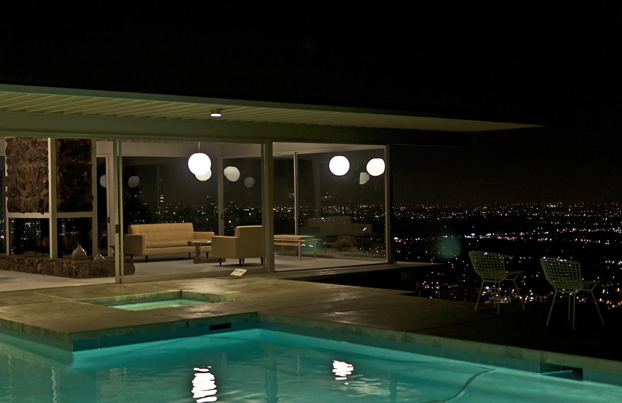 a home at night with lights around the pool