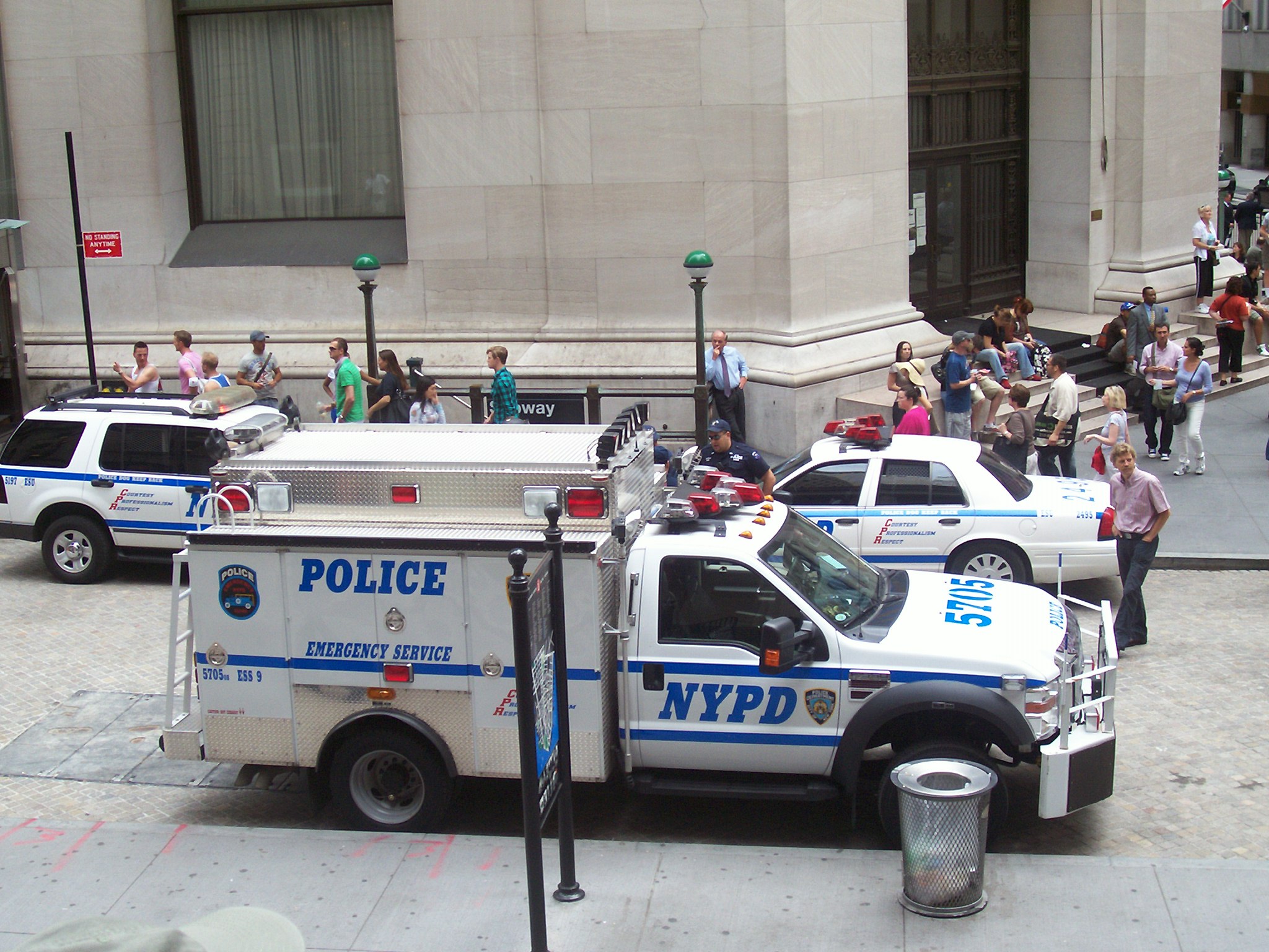 police trucks and people on the sidewalk outside