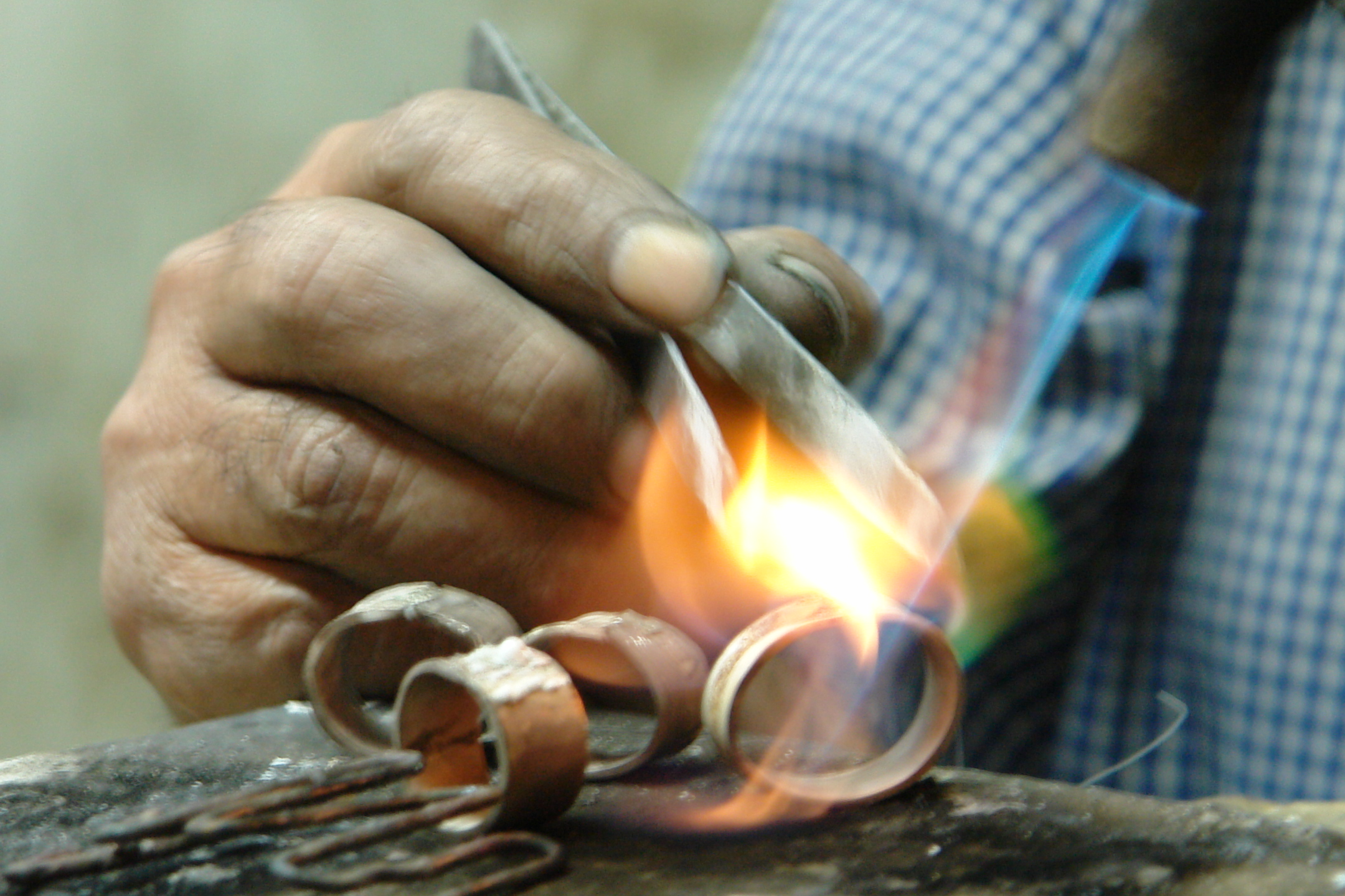 a person is welding some pieces of metal with an iron scissors