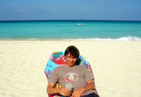 a man lying on his stomach in a beanie chair on the beach