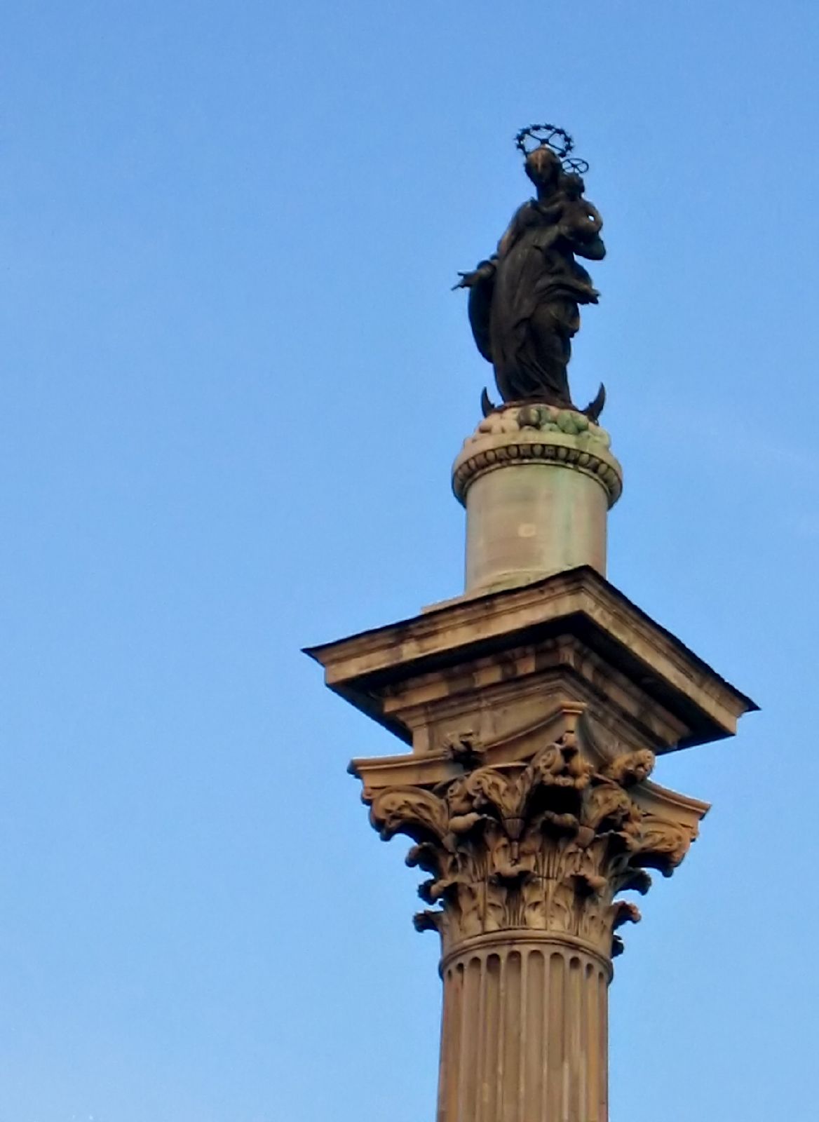 the statue is on top of the building with a bird on its head