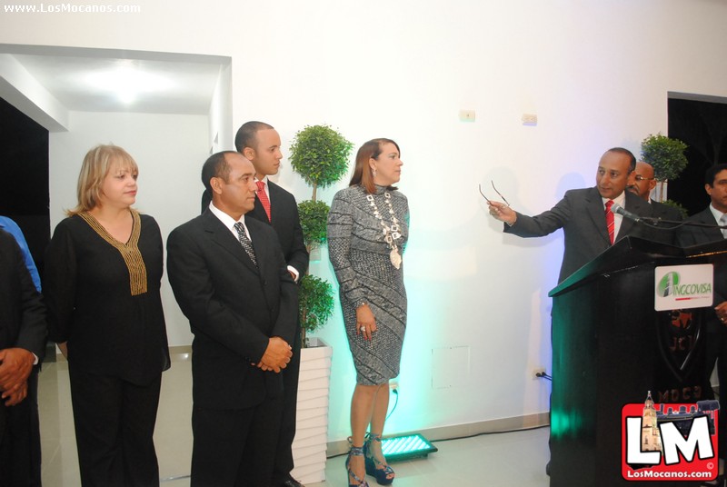 woman in business attire standing behind podium addressing people