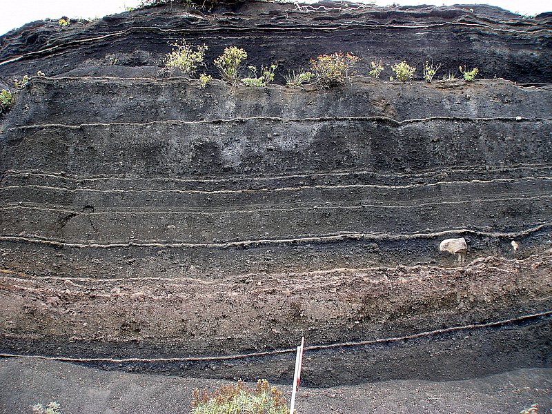 the slope is under the mountain with rocks and grass on it