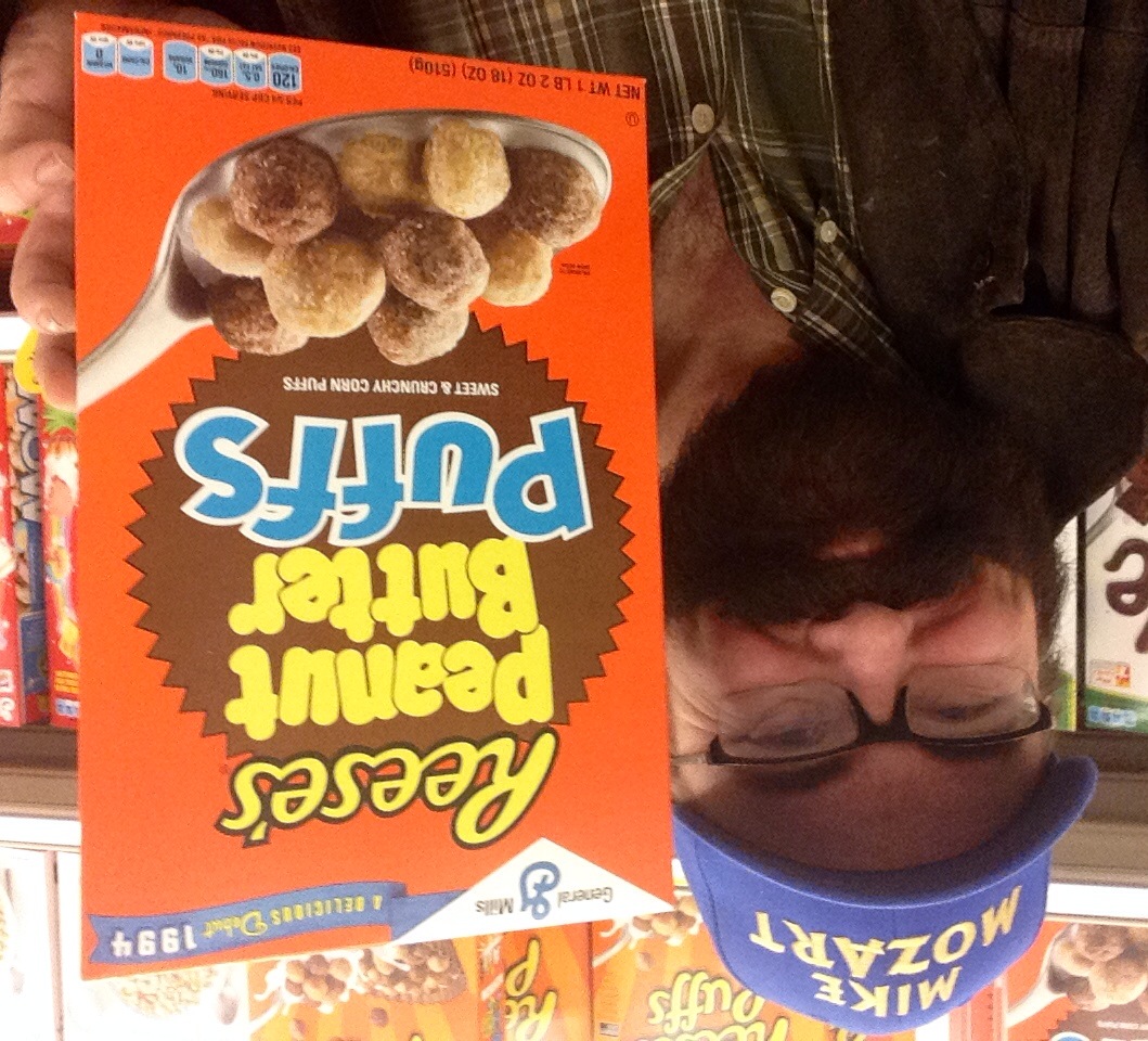 a man holding up a box of reese's peanut er puffs