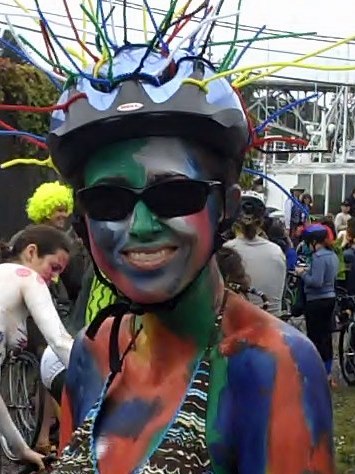 people with colorful costumes at a party on bicycles