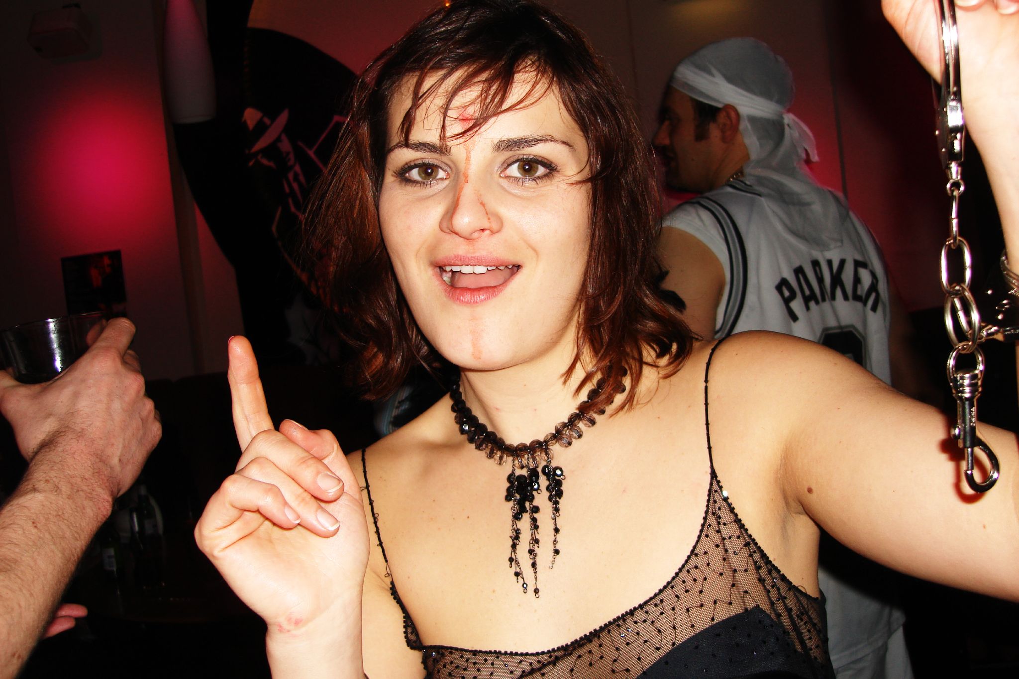 a woman wearing an emo style necklace pointing