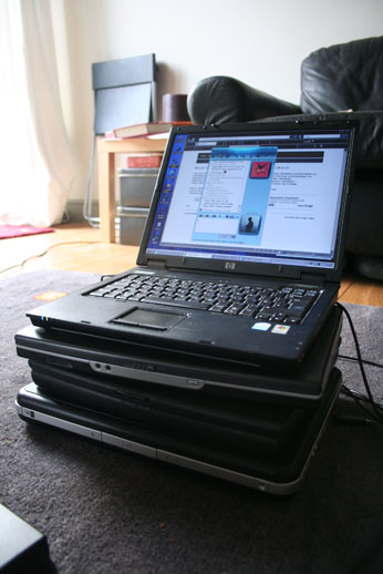 a laptop computer sitting on top of three books