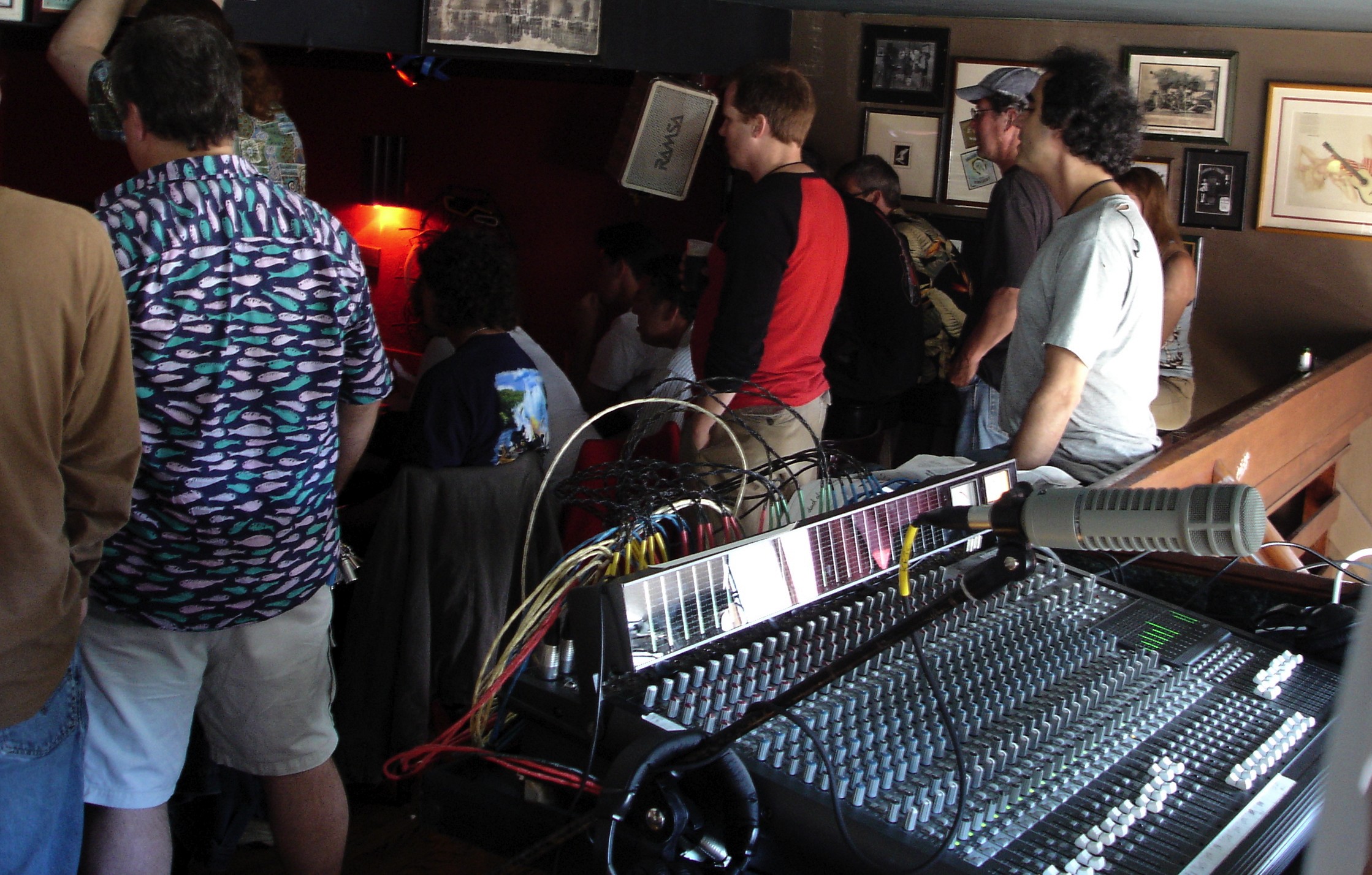 a group of people in a room with an electronic mixing console