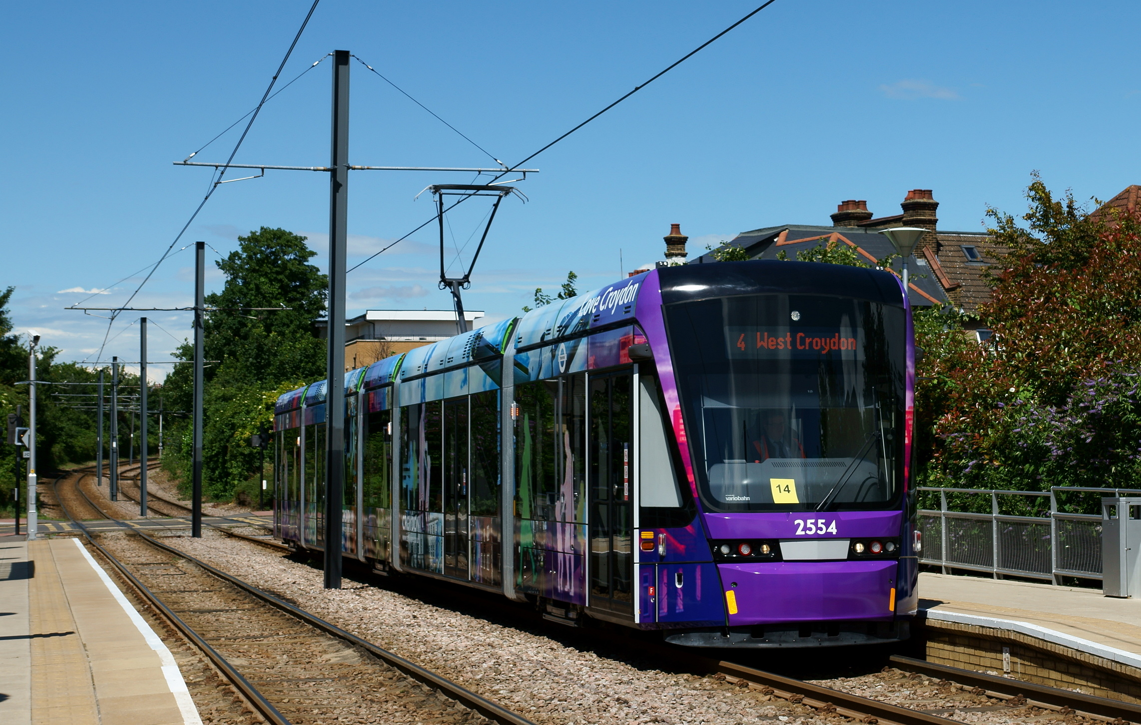 a purple and blue train pulling into a station