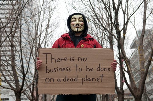 a man holding a sign with a guy wearing a mask holding a sign