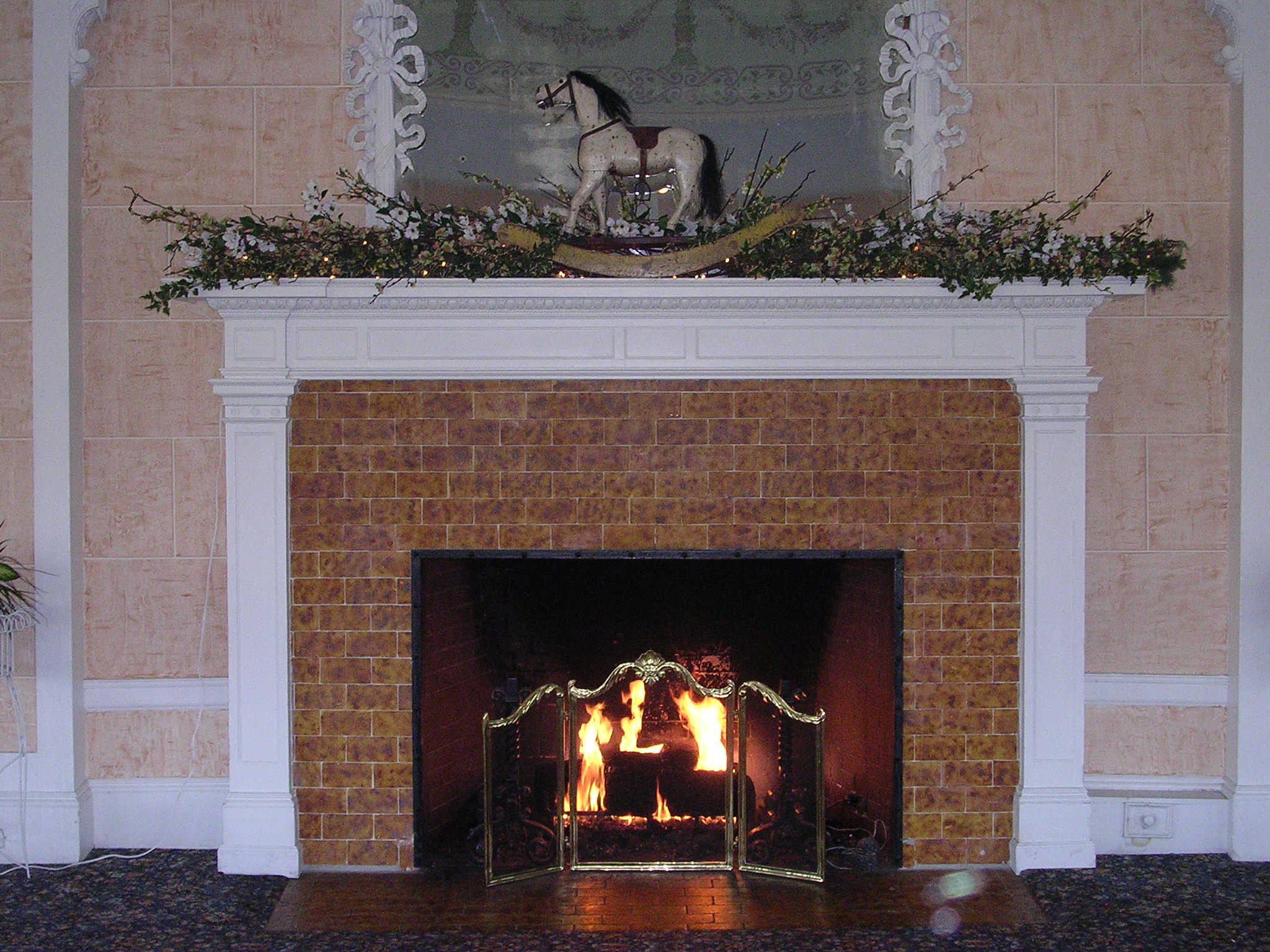 a fireplace with an artificial horse on top