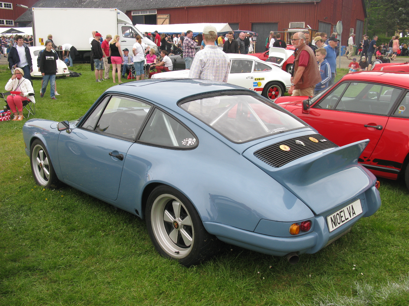 an old blue car is parked in the grass