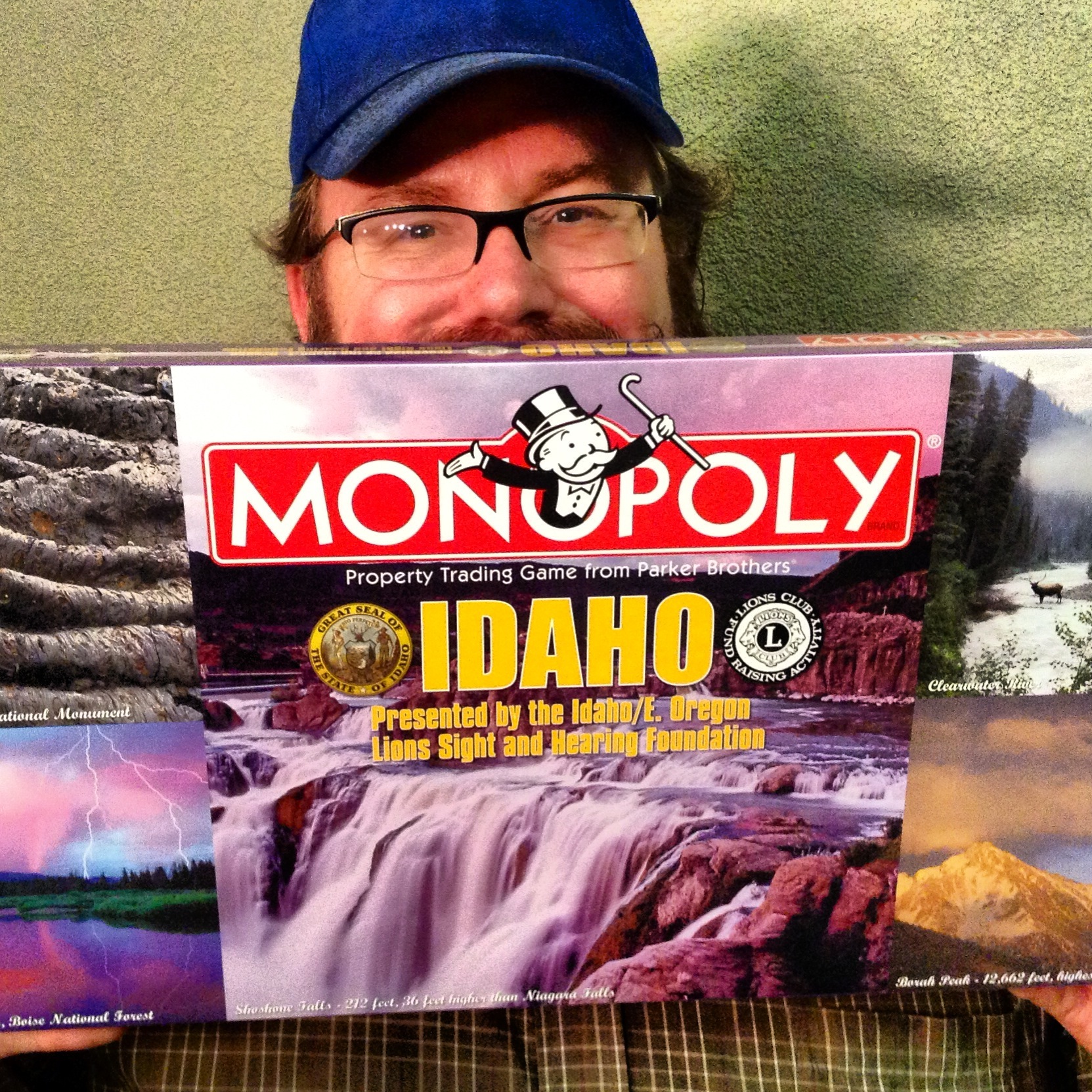 a man smiling holding up his copy of monopoly idaho