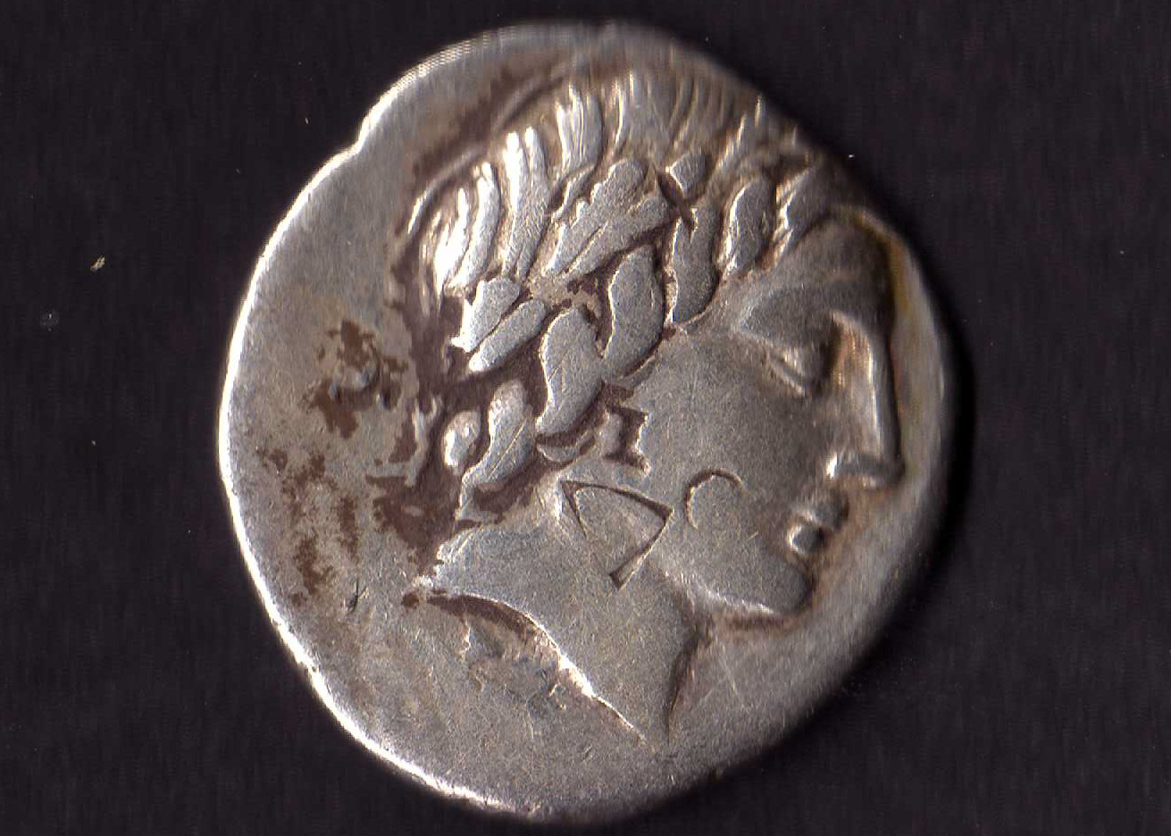 a large silver coin with a hair piece on the inside of it