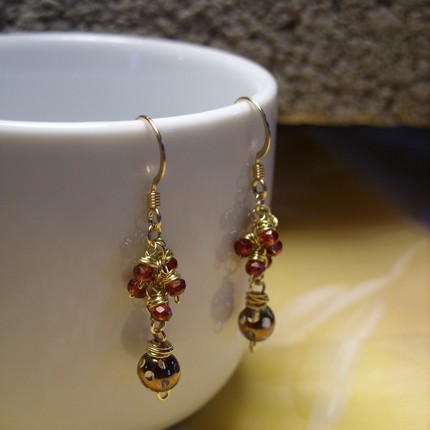 a pair of gold and garnet earrings with tiny beads