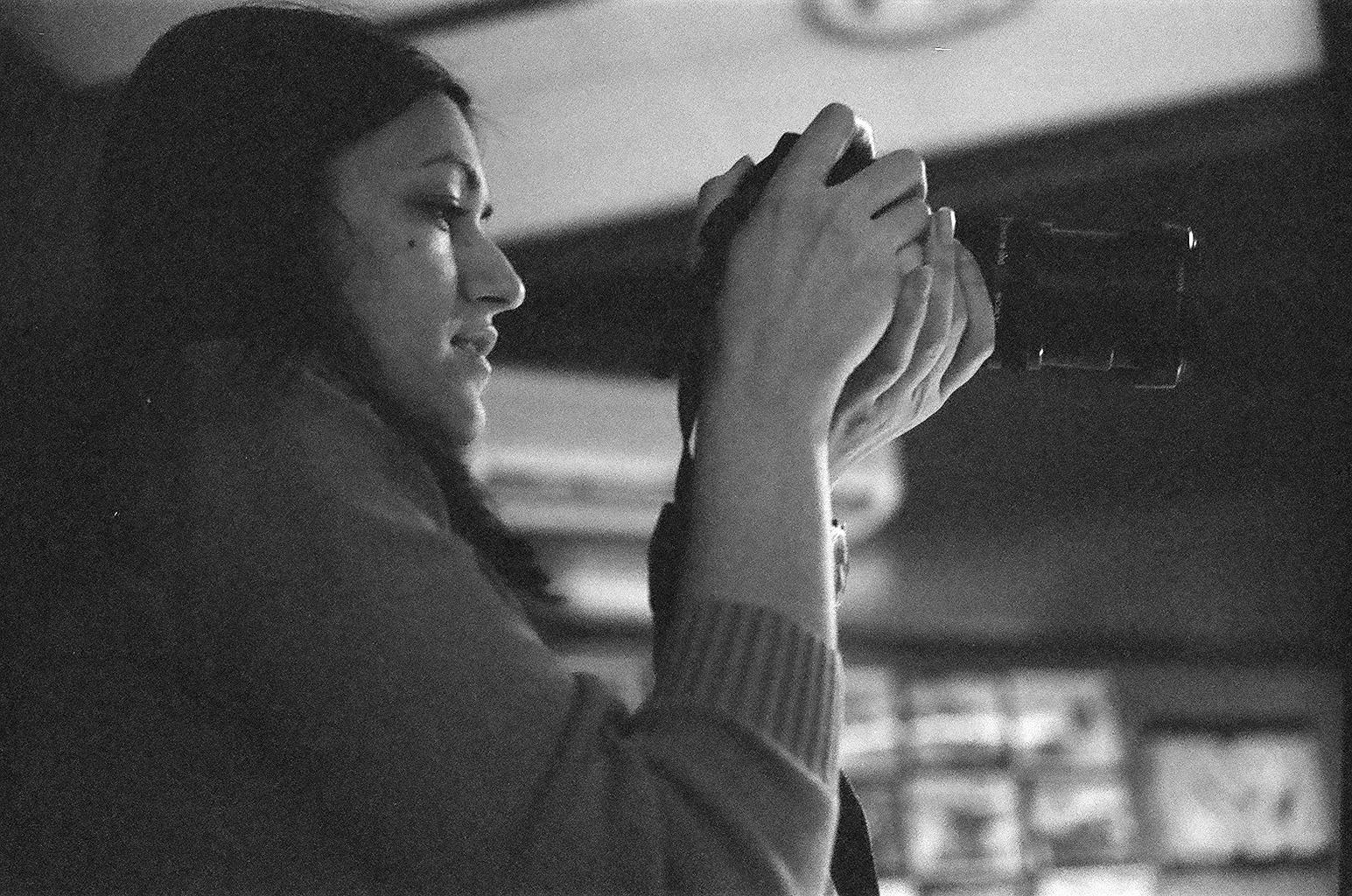 a woman sitting at a bar drinking from a cup