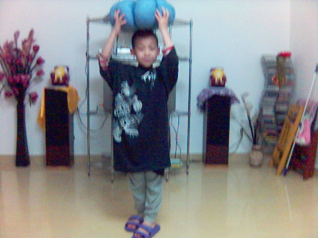 an asian child in a room playing with a ball