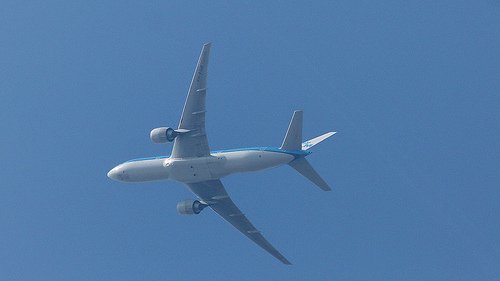 an airplane flying through the clear blue sky