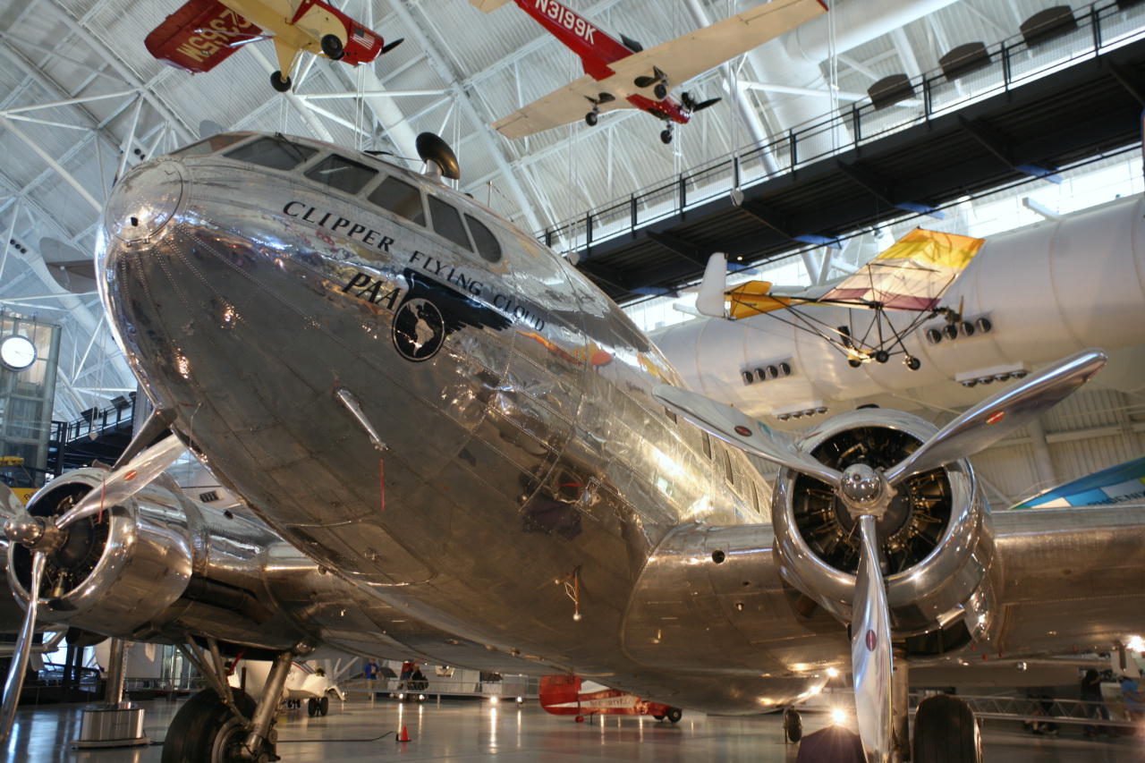 an older silver airplane parked inside of a building