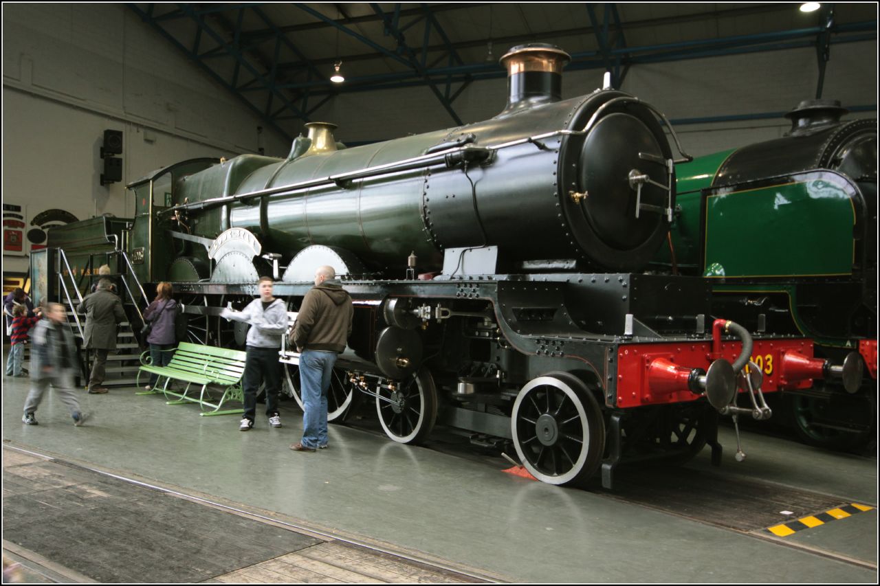 a group of people standing next to an old train