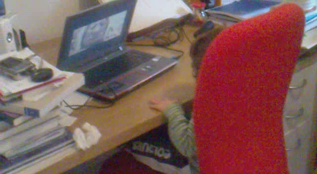 a person sits in an office chair with his head down and his laptop sitting on the desk,