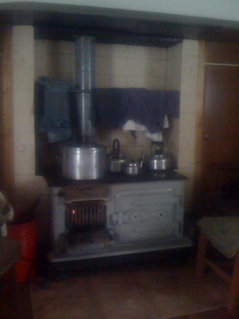 an old fashioned kitchen with various pots and pans