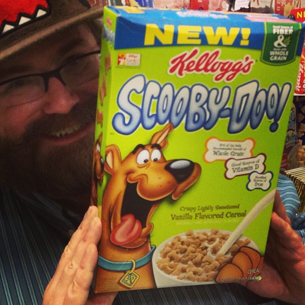 a man is holding a cereal box and smiling