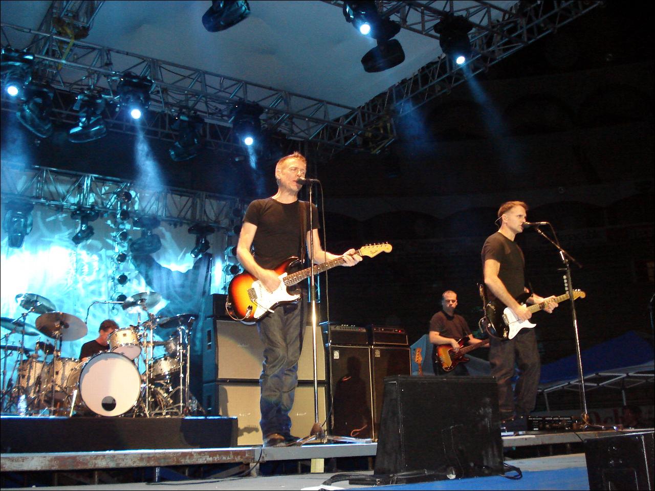 the band performs on stage at night