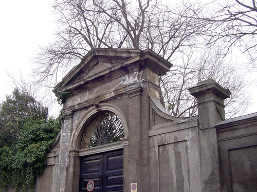 a large gray gate surrounded by a stone wall