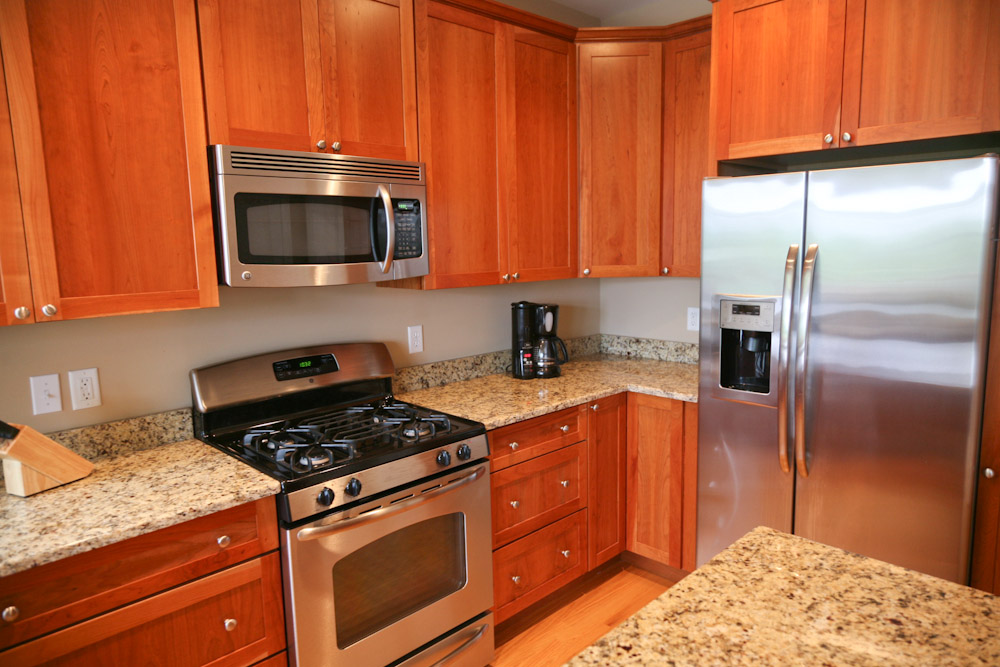 a large stainless steel kitchen has granite counters