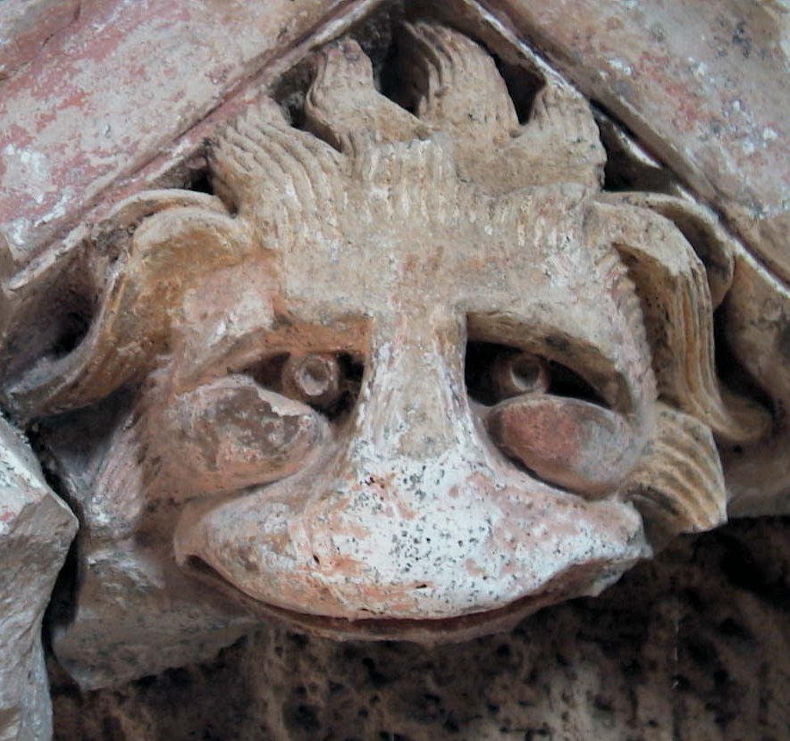 a decorative face is placed on a brick wall