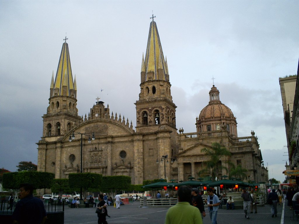 the cathedral of an old town with pedestrians in front