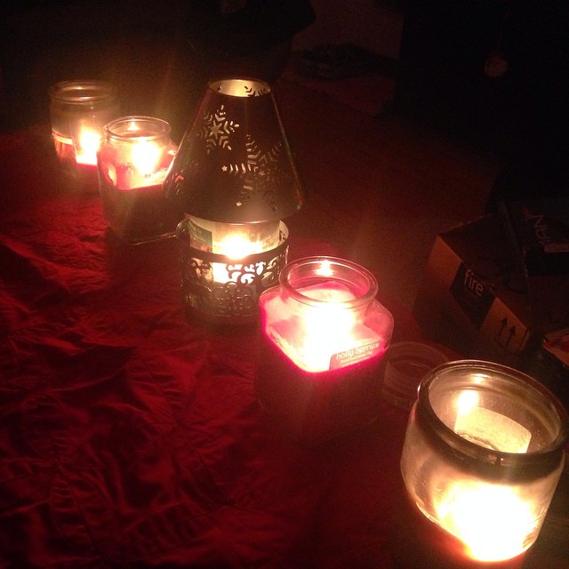 several lit candles are laying on a red blanket