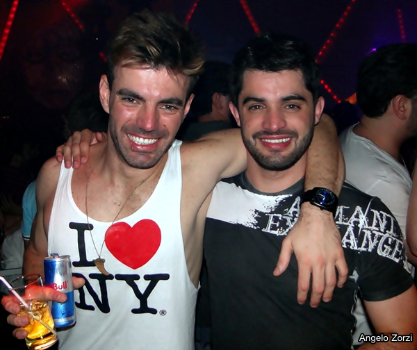 two men at a nightclub posing for the camera