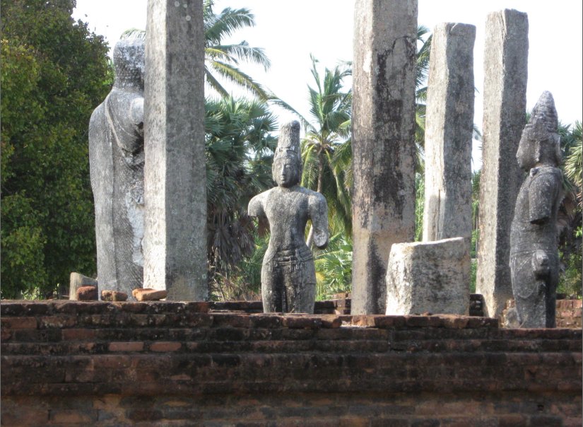 four sculptures of people and trees are in the background