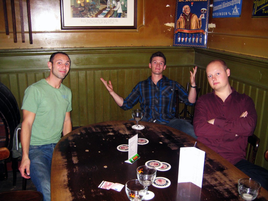 three men sit around a table and enjoy the moment